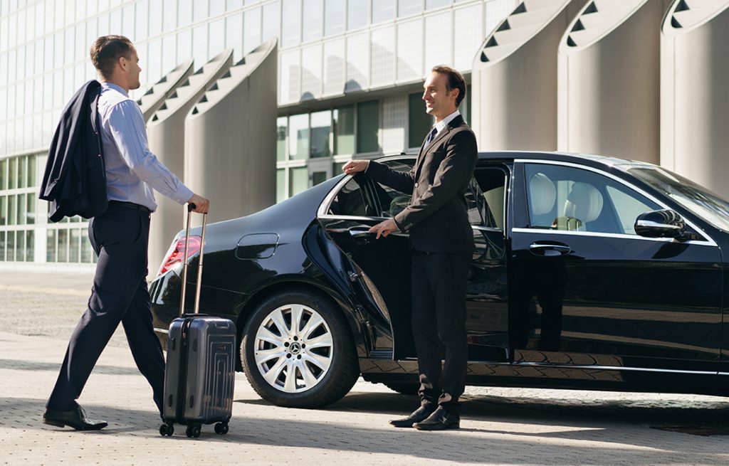 Chauffeur standing next to a car